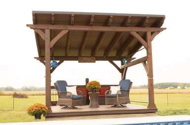 Wooden Brookside Timber Frame Rose Beam Pavilion on a deck with seating, set in an open countryside view