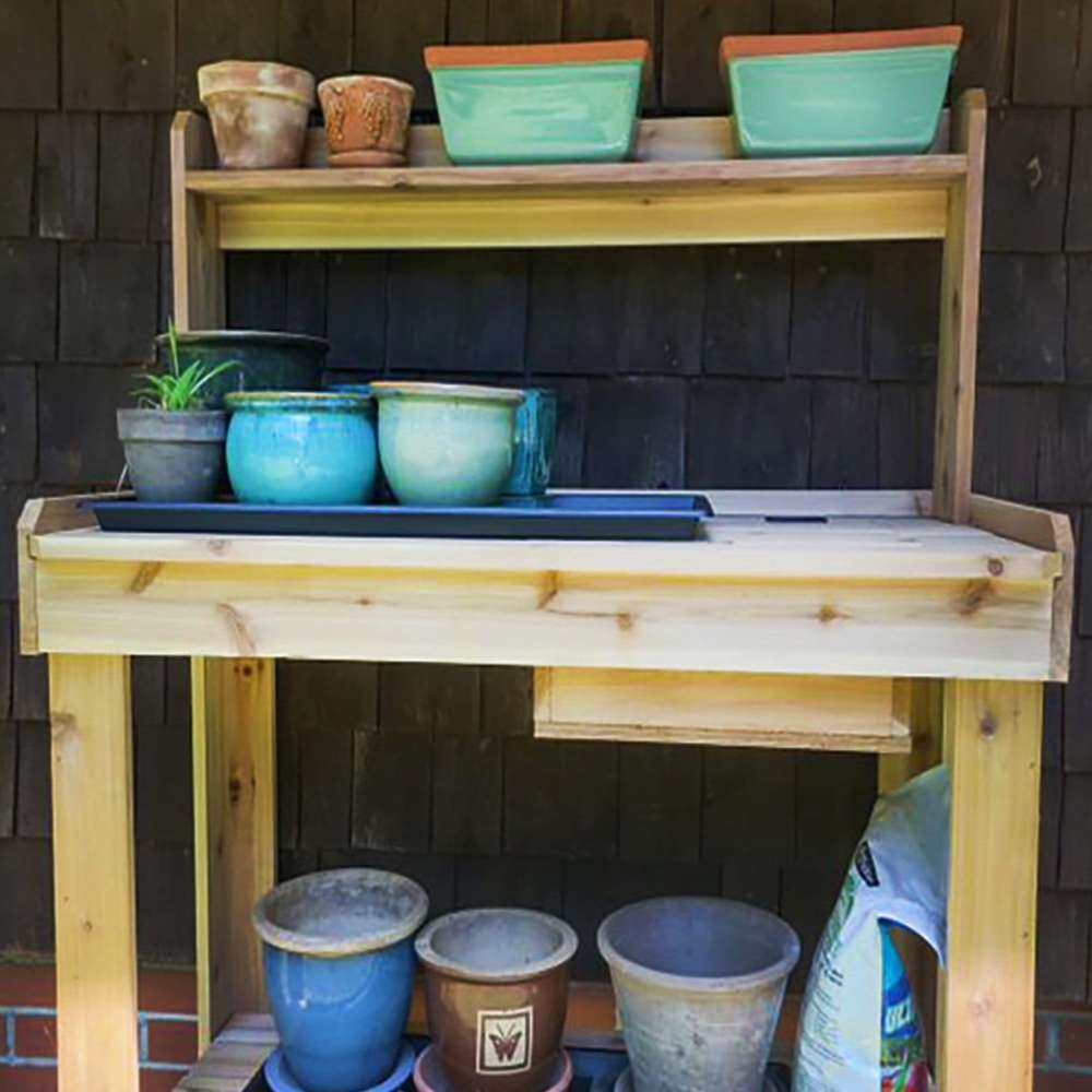 Wooden bench displays pots and trays neatly, with Outdoor Living Today 4×2 Western Red Cedar Potting Bench at the center