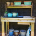 Wooden bench displays pots and trays neatly, with Outdoor Living Today 4×2 Western Red Cedar Potting Bench at the center