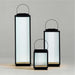 All three sizes of the Crate & Barrel Alfresco Black Metal and Glass LED Solar Outdoor Lantern shown together from an angle