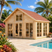 Bright daytime view of the Bern 70 wooden cabin functioning as a dual home office next to a swimming pool, surrounded by tropical palm trees and flora.