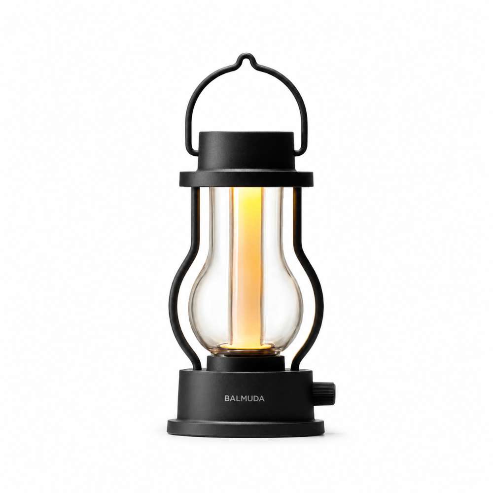 Black Crate & Barrel Balmuda LED Rechargeable Outdoor Lantern with a black body, metal carry handle and a central tube that guides the light downward