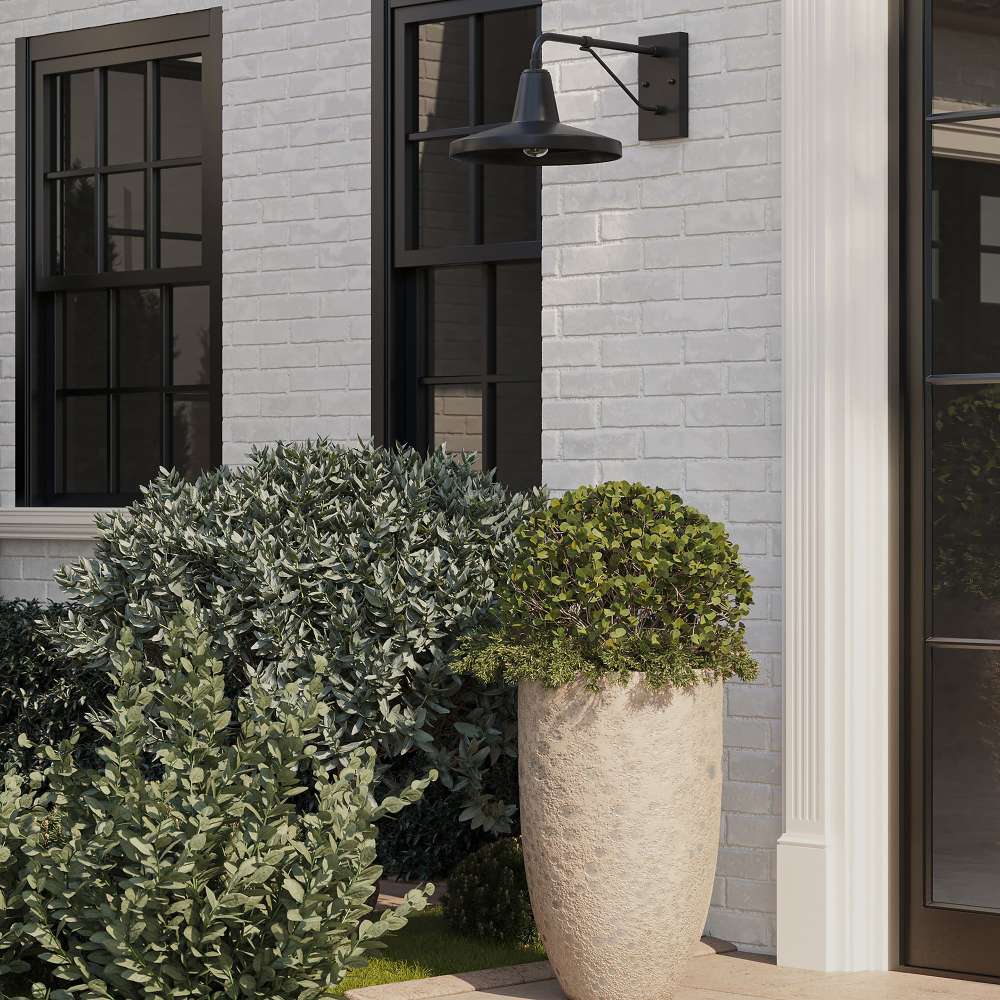 Black Crate & Barrel Mariner Outdoor Wall Sconce shown from an angle to reveal the faceted shade and cantilever bracket