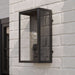 Black Crate & Barrel Royster Black Outdoor Wall Sconce in matte black solid brass with a hardwired mounting plate and open lantern frame, shown in the fourth alternate view