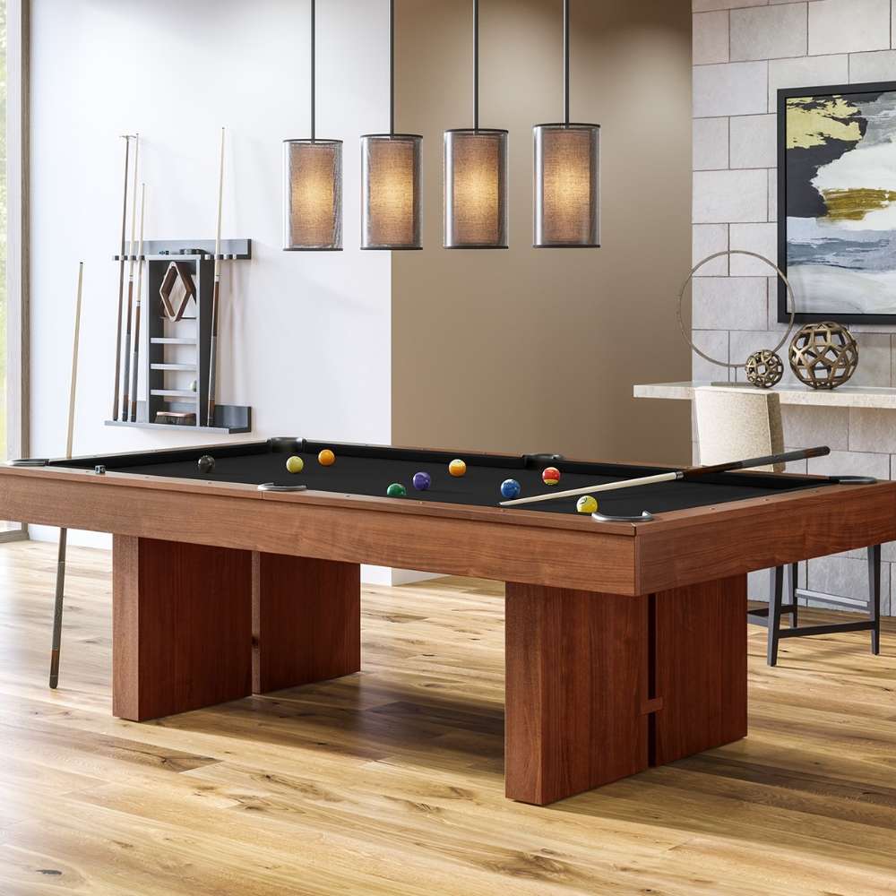 Black Crate & Barrel Walnut Pool Table with Wall Rack and Accessories at an angle in a game room under four pendant lights with coloured balls on the black felt and a wall cue rack behind