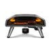 Black Ooni Koda 2 Pro Pizza Oven front view with a pepperoni pizza and a tray of roasting food side by side on the stone.