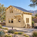BlueWater Freedom Loft Studio configured as a backyard office in a sunny Nevada desert garden, with two adults working inside the compact 160-square-foot timber structure.
