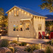 BlueWater Freedom Loft Studio illuminated for a bright Nevada sports night, with friends watching a game inside and warm landscape lighting surrounding the timber structure.
