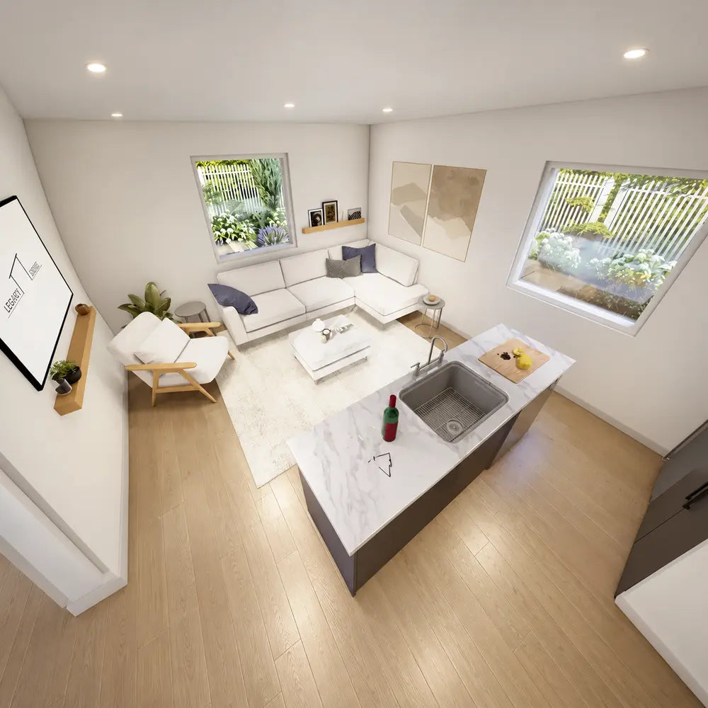 Top-down view inside the Jasper Garden Suites showing an open-concept living area with a marble kitchen island, white sectional sofa, armchair, and large windows.