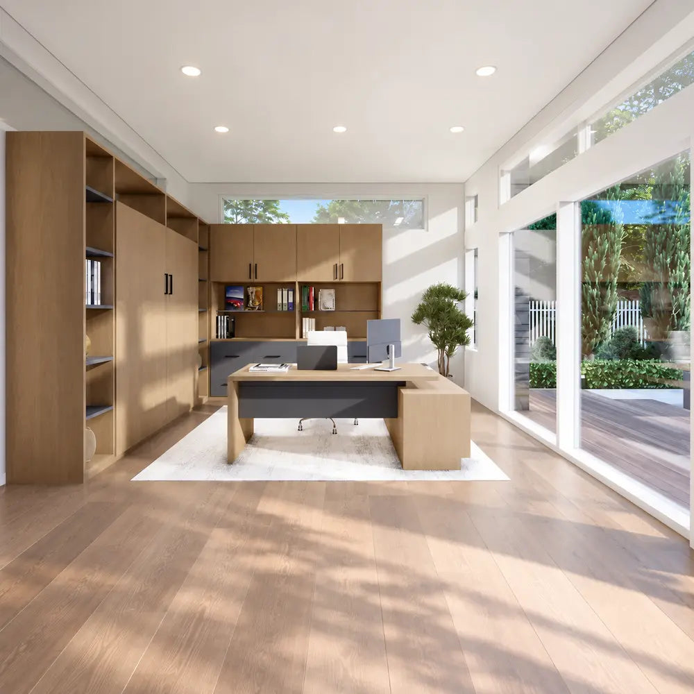 Bright office inside the Algonquin Garden Suites with a modern wooden desk, computer equipment, integrated cabinetry, indoor plant, and large garden-facing windows.