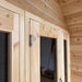 Close-up of a sturdy silver door hinge mounted on the smooth natural wood frame of the Sawmill Structures CabinSauna.