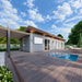 Side view of the Jasper Garden Suites with gray exterior cladding, sliding glass doors, a shaded pergola lounge, wood decking, and a plunge pool.