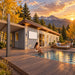 Side-angle view of the Jasper one-bedroom Freedom Suite at golden hour, with four adults enjoying drinks beside the pool amid golden aspens, evergreen trees, and Colorado mountain scenery.
