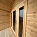 Wooden entrance of the Sawmill Structures CabinSauna featuring tall glass panels, natural wood framing, and a black door handle.