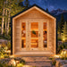 The warmly illuminated CabinSauna on a bright Colorado night, with two adults enjoying a traditional sauna session beneath a star-filled sky and Rocky Mountain backdrop.