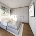 Cozy white bedroom inside the Tremblant Garden Suites with a large bed, full-wall cabinetry, abstract artwork, narrow window, and wall-mounted television.