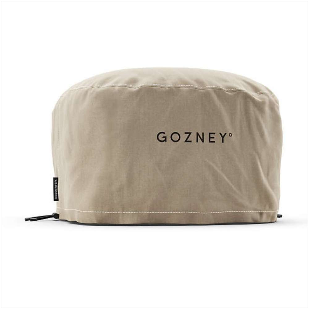 Gozney Arc Lite Pizza Oven Cover angled on white showing the sand-colored canvas the Gozney wordmark and a small label on the seam.