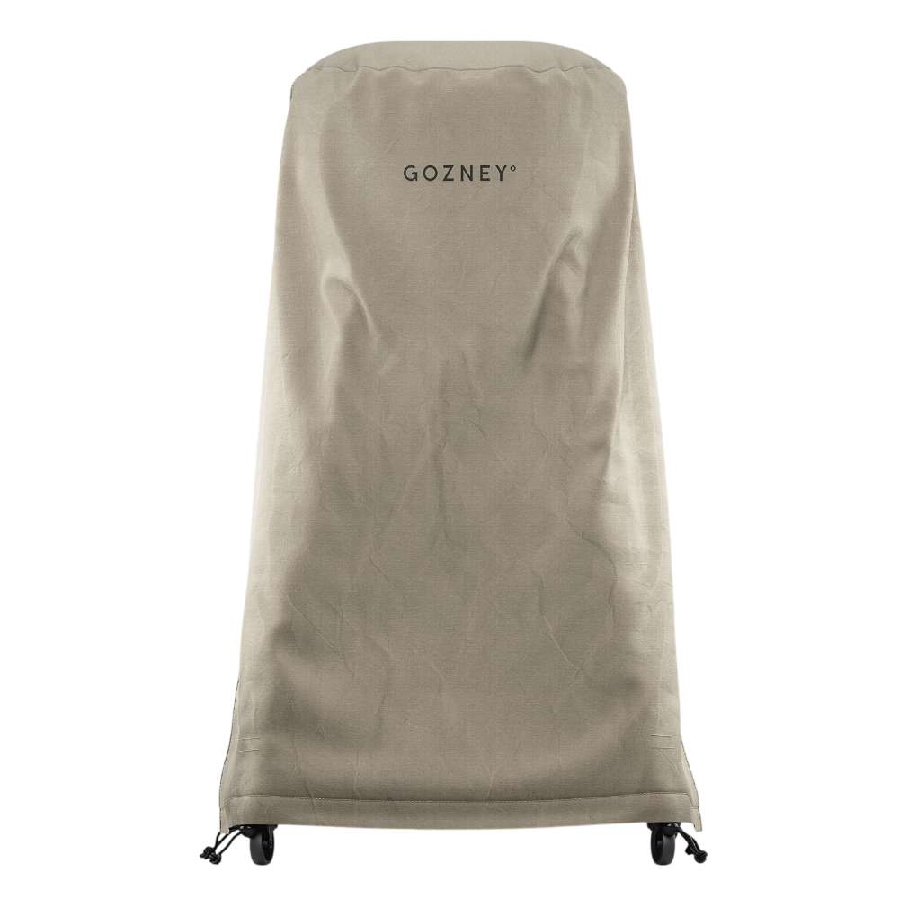 Gozney Arc Pizza Oven + Stand Cover on white showing the tall stone-colored canvas cover fitted over the oven and stand with the Gozney wordmark near the top and casters at the base.