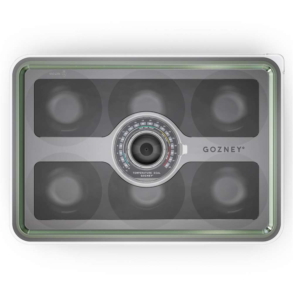 Gozney Pizza Dough Tray overhead view on white of the clear lid showing the six round wells beneath and the Gozney wordmark beside the central dial.