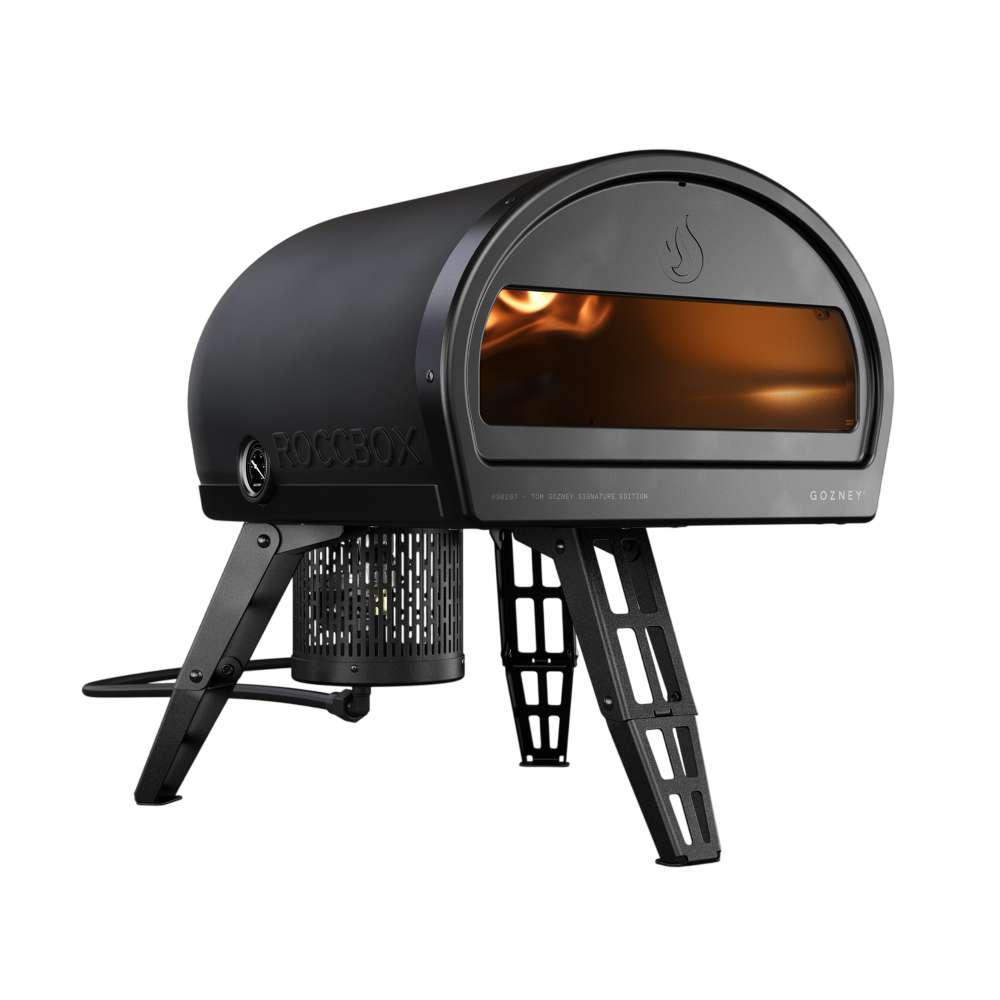 Gozney Roccbox Black Outdoor Portable Pizza Oven angled side view on white with an orange flame glowing inside the mouth and the folding legs extended.