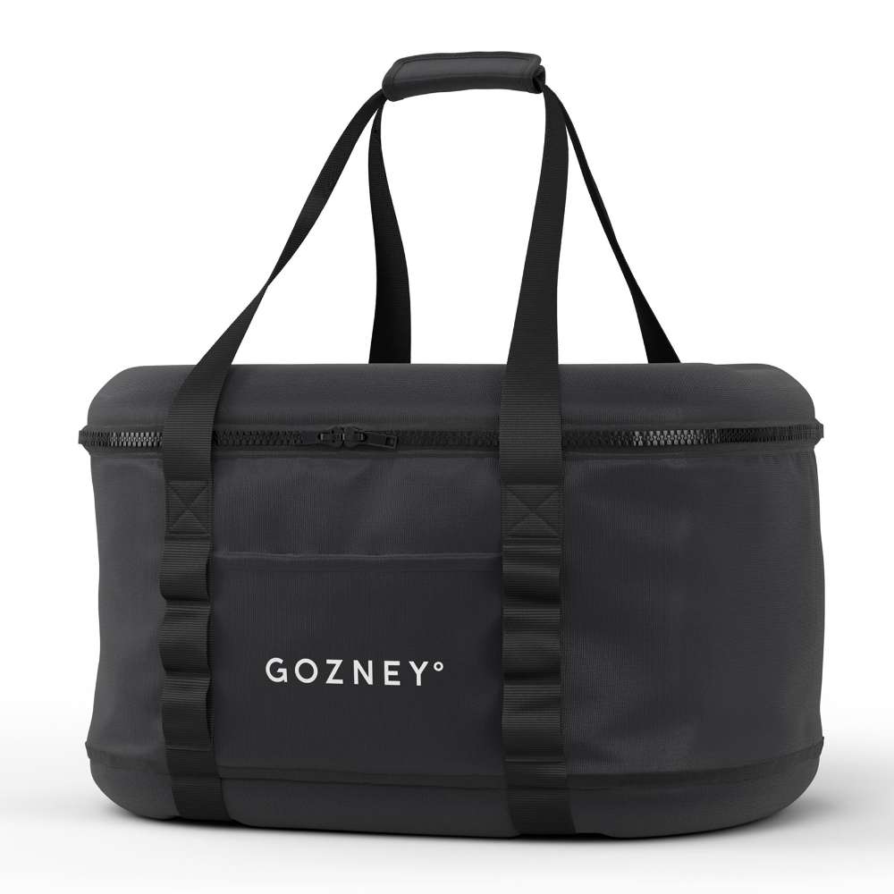 Gozney Tread Travel Bag angled on white showing the zippered black shell and the twin webbing handles.