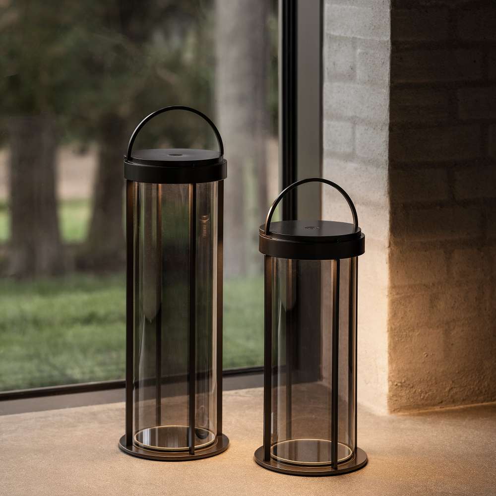 Gunmetal Crate & Barrel Blomus Mituro Rechargeable LED Indoor/Outdoor Lantern shown in a styled setting, cordless and lit from the top and bottom of the glass shade