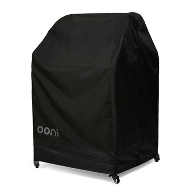 Large Ooni Table and Pizza Oven Cover angled view of the black cover with the ooni logo over a wide table on casters.