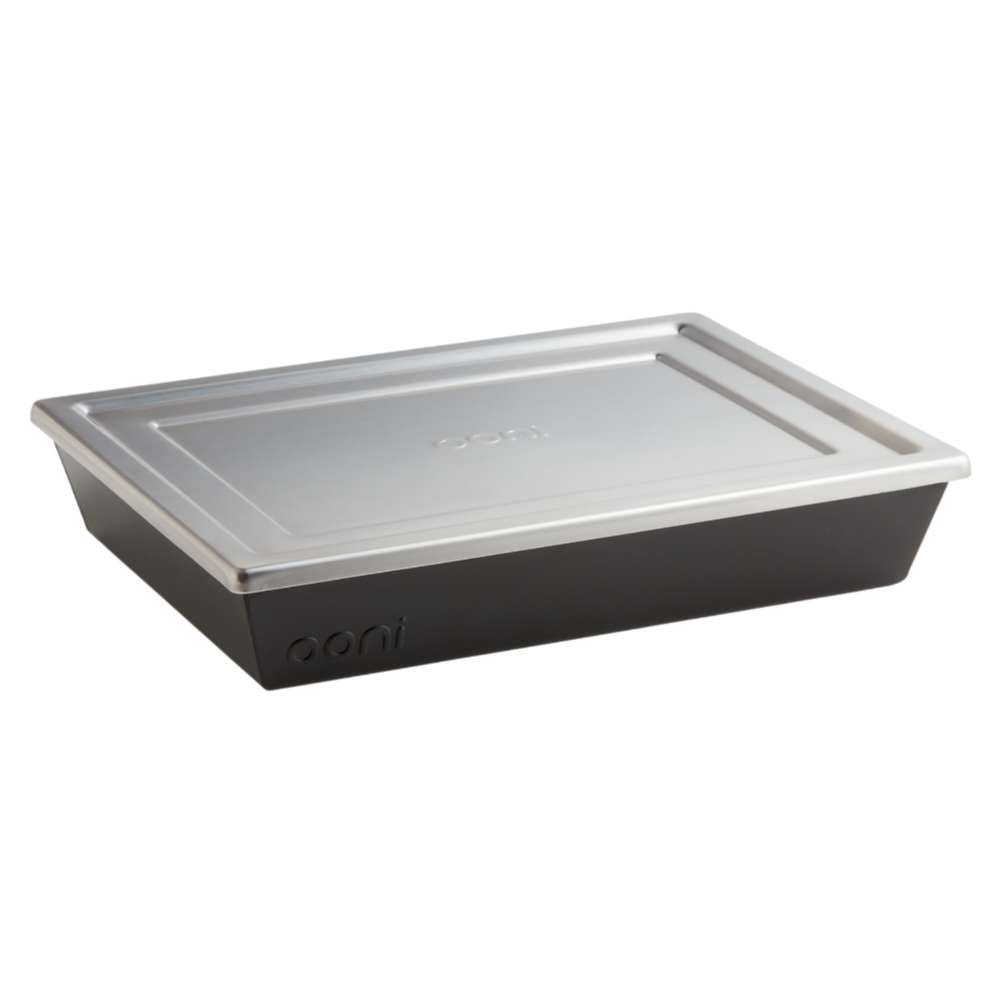 Medium Ooni Detroit Pizza Pan angled view with the stainless steel lid resting on the black pan and the ooni logo embossed on the side.