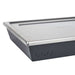 Medium Ooni Detroit Pizza Pan close-up of one corner with the brushed stainless steel lid overhanging the dark gray pan and the ooni logo below.