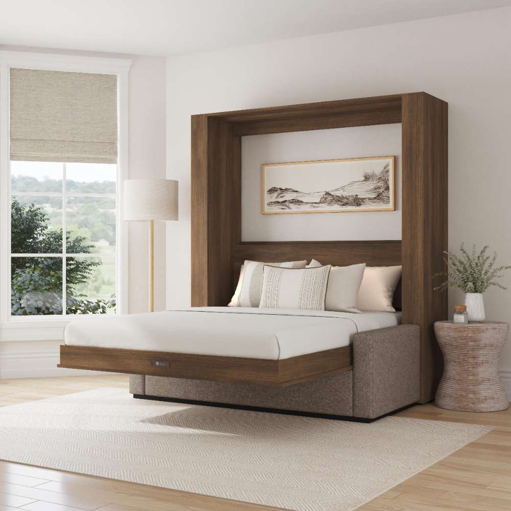 Modern Walnut Inovabed Wall Bed with Sofa and Wide Flex Cabinet opened in a bright room with white bedding, a framed landscape print above the headboard and a woven side table beside it