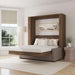 Modern Walnut Inovabed Wall Bed with Sofa and Wide Flex Cabinet opened in a bright room with white bedding, a framed landscape print above the headboard and a woven side table beside it