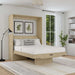 Natural Oak Inovabed Murphy Bed with Desk opened in a bright bedroom with white bedding, a striped lumbar pillow and two framed botanical prints above the headboard