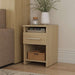 Natural Oak Inovabed Wall Bed with Sofa and Two Nightstands showing one nightstand beside the sofa, styled with a vase of greenery, a candle, books in the open cubby and a woven basket below