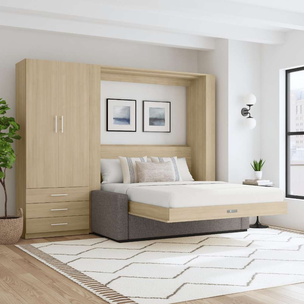 Natural Oak Inovabed Wall Bed with Sofa and Wide Flex Cabinet opened in a bright room beside the Wide Flex Cabinet, with white bedding, a gray sofa base and two framed prints above the headboard