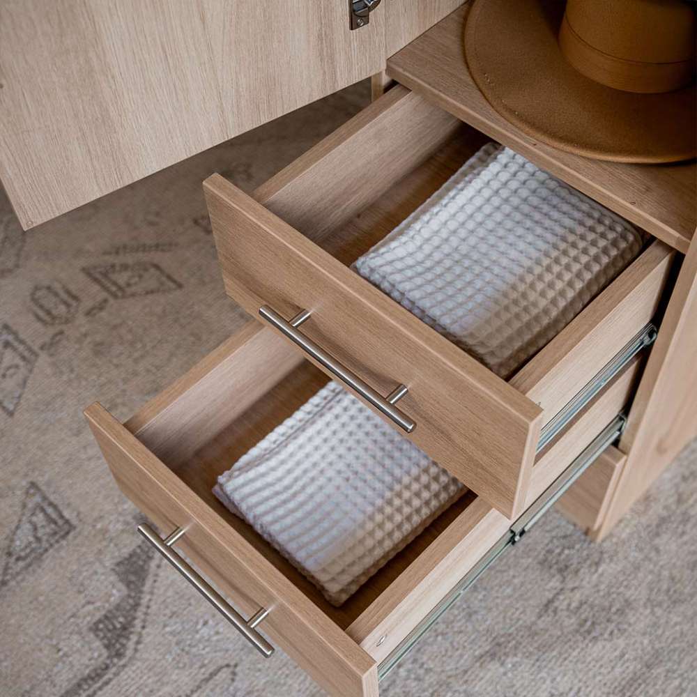 Natural Oak Inovabed Wall Bed with Table and Two Narrow Flex Cabinets in close-up with two Narrow Flex Cabinet drawers pulled open on folded towels and a hat resting above