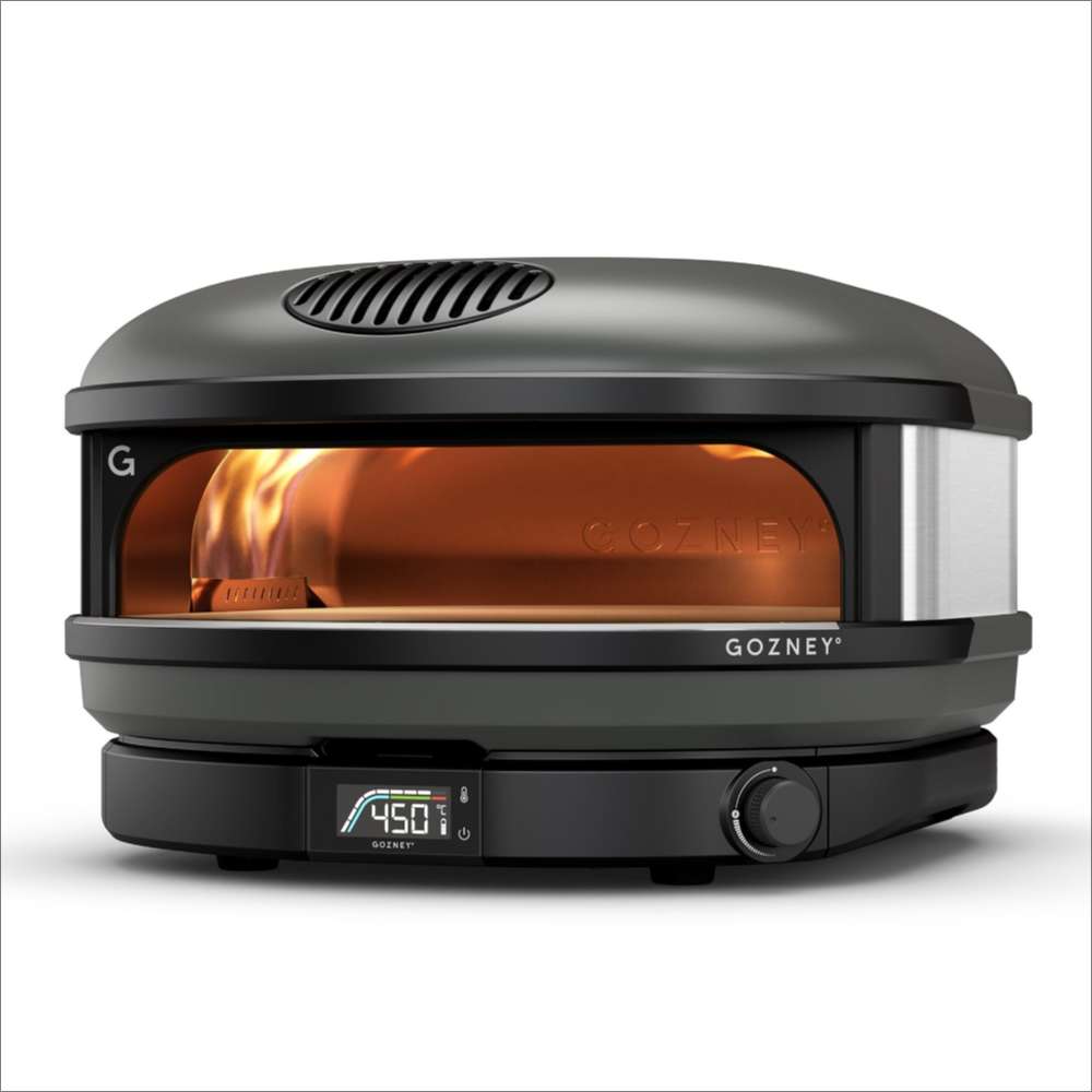 Off-Black Gozney Arc XL Pizza Oven angled view on white with an orange flame burning inside the copper-toned dome and the display reading 450.