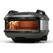 Off-Black Gozney Tread Pizza Oven angled front view on white with a flame inside the copper-toned dome and the two black carry handles on top.