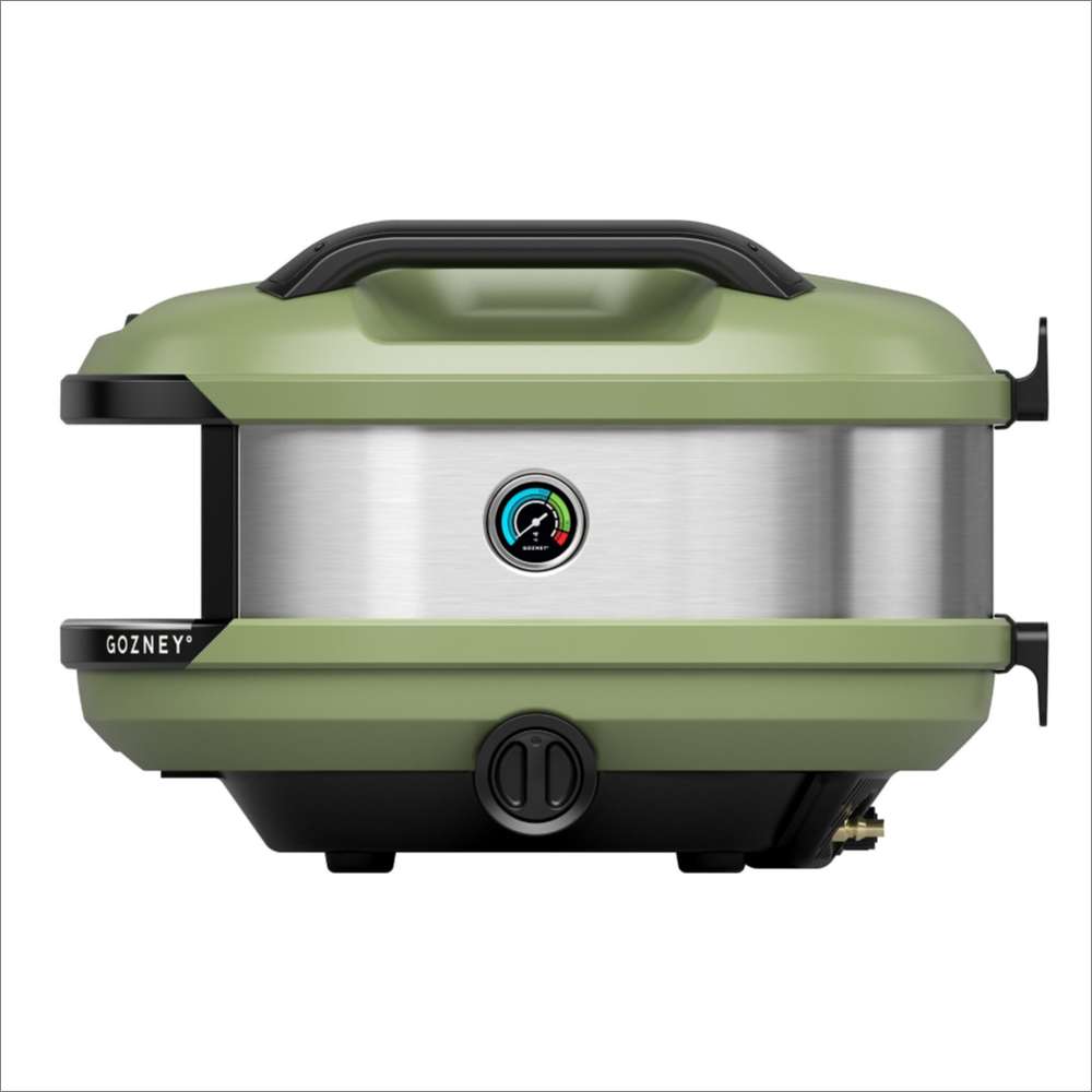 Olive Gozney Tread Pizza Oven side profile on white showing the green shell and the brushed stainless side panel with its round temperature gauge.