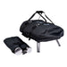 Ooni Fyra Outdoor Pizza Oven Carry Cover zipped over the oven with a padded shoulder strap and buckled straps on top, the stainless steel legs showing below, and a separate black drawstring bag holding the chimney in front.