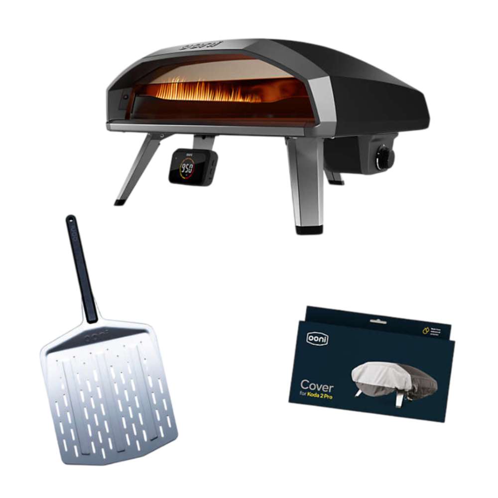 Ooni Koda 2 Pro Essentials Bundle with the black gas pizza oven showing flames and a display reading 950, a perforated stainless steel pizza peel, and a navy box printed Cover for Koda 2 Pro.