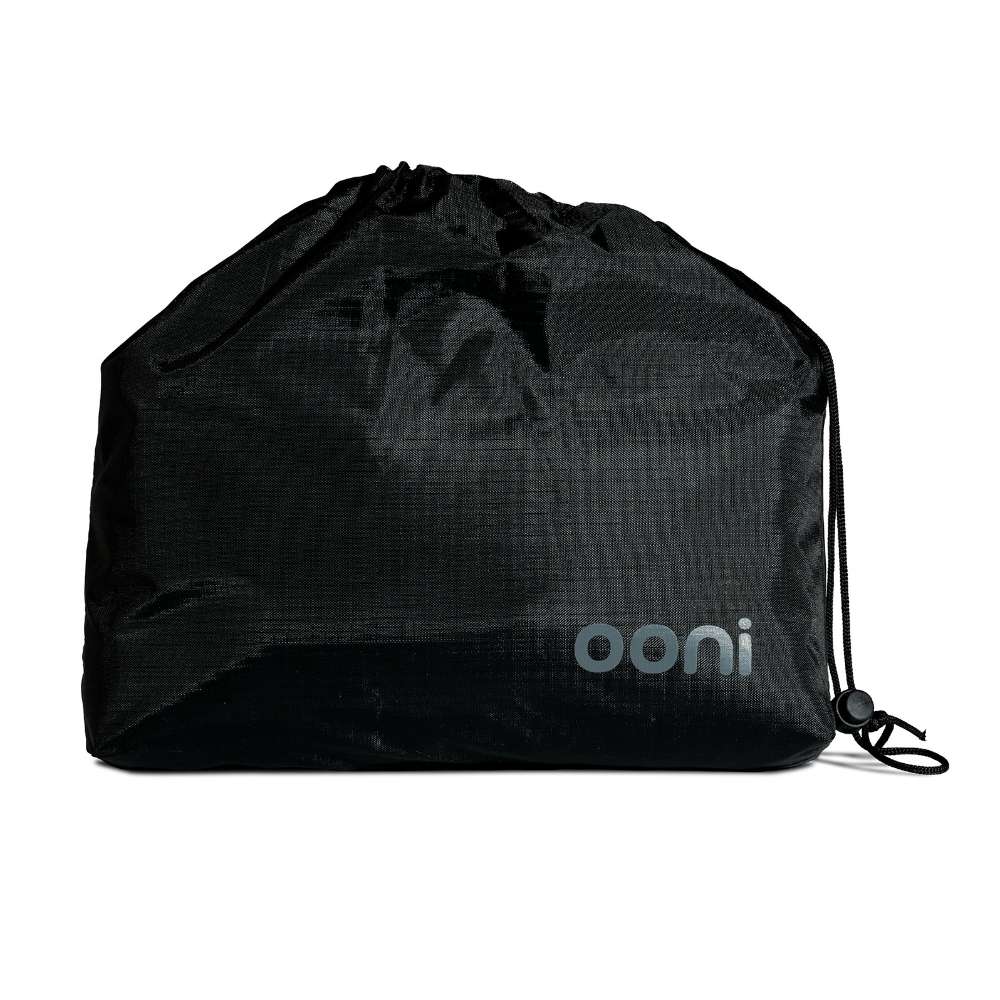 Ooni Table and Pizza Oven Cover packed into its black drawstring storage bag with the ooni logo on the front.
