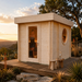 Sauna Tuuli 90 glowing at golden hour with two adults stretching and cooling down inside above a scenic Texas Hill Country slope.