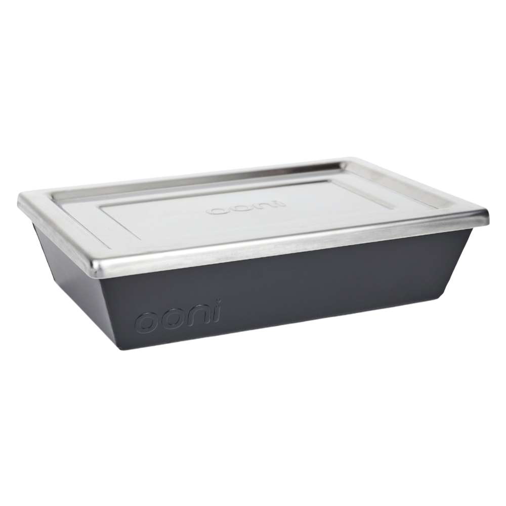 Small Ooni Detroit Pizza Pan angled view with the stainless steel lid resting on the dark gray pan and the ooni logo embossed on the side.