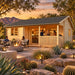 The Sunbeam Lakehouse 70mm transformed into a golden-hour entertainment bar, with friends socializing inside, on the covered porch, and beside a fire feature.
