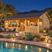 The Sunbeam Lakehouse 70mm illuminated for a bright Nevada sports night, with friends watching a game indoors and enjoying drinks on the covered porch.

