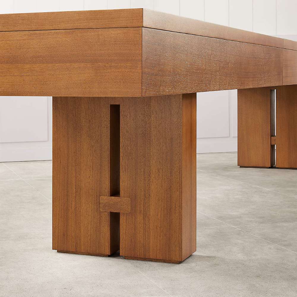 Walnut Crate & Barrel Shuffleboard in close up on one slab leg and the underside of the cabinet, standing on pale grey tile against a white panelled wall