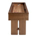Walnut Crate & Barrel Shuffleboard seen end on against a white background, looking along the pale maple playfield to red and black pucks at the far end above the cabinet and two slab legs