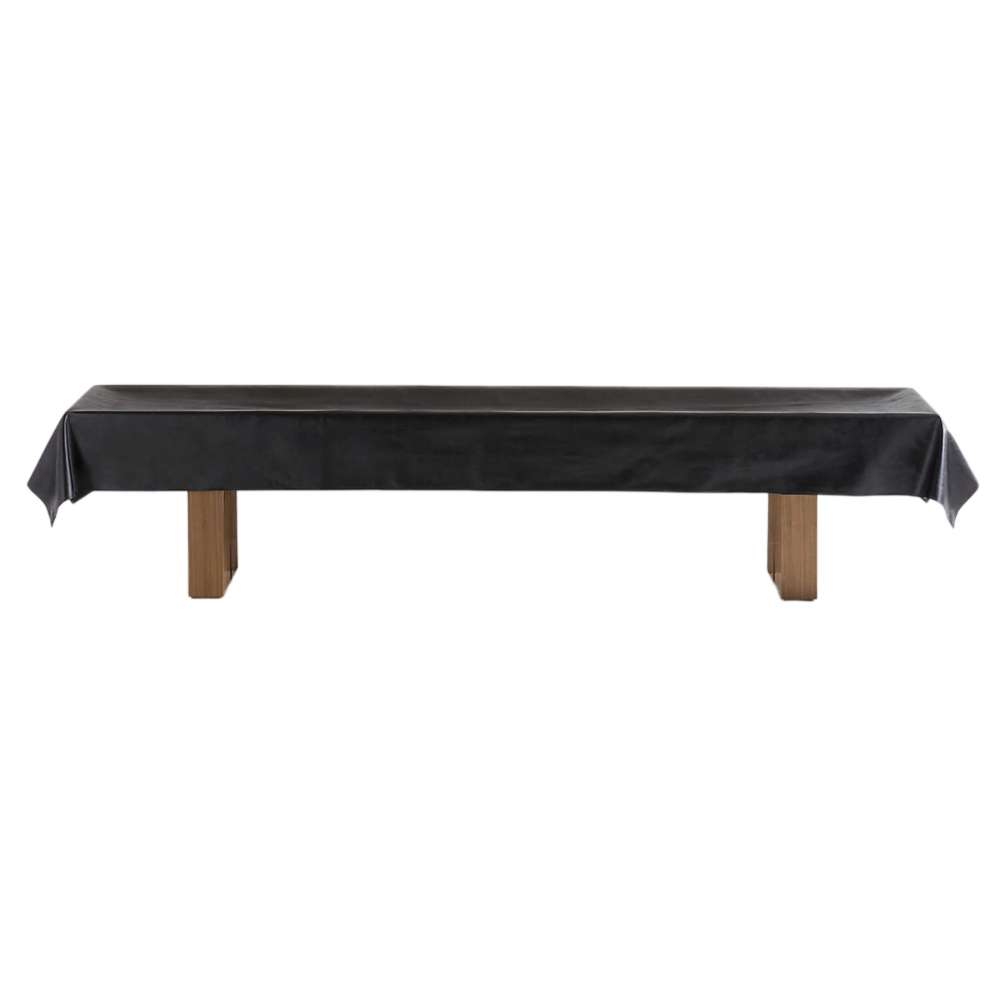 Walnut Crate & Barrel Shuffleboard seen from the side on a white background with the included black protective cover draped over the cabinet and the wood legs visible below