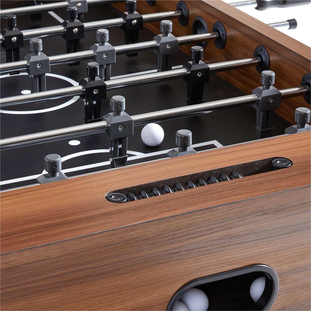 Walnut Wood Crate & Barrel Modern Wood Foosball Table in close up on the black playing field with a white ball, chrome rods and a black bead score counter set into the wood rail