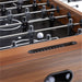 Walnut Wood Crate & Barrel Modern Wood Foosball Table in close up on the black playing field with a white ball, chrome rods and a black bead score counter set into the wood rail